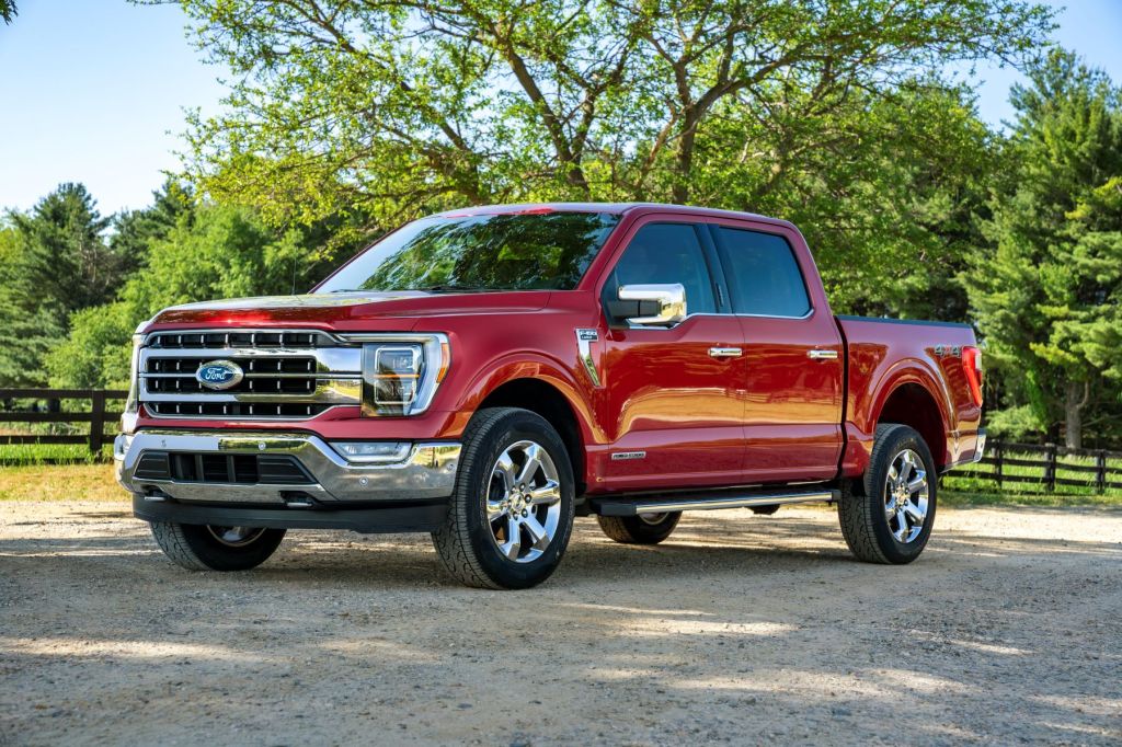A red 2021 Ford F-150 Lariat full-size pickup truck model parked on a gravel trail