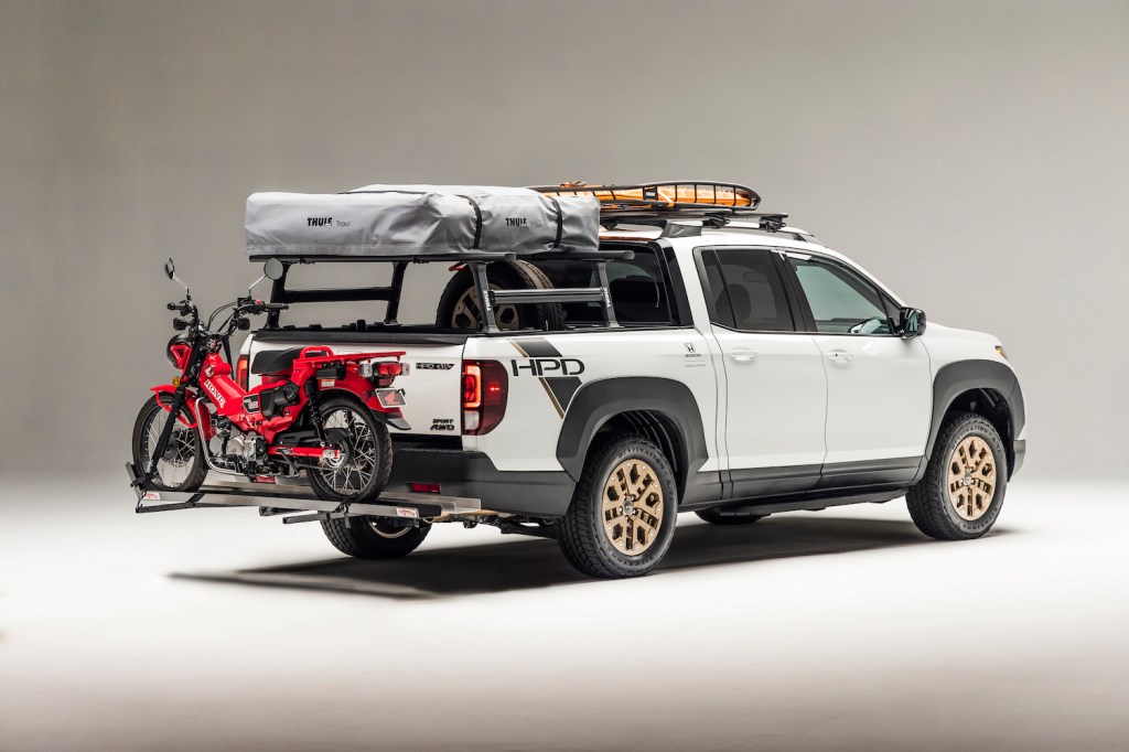 Honda Ridgeline pickup truck loaded with a roof rack and motorcycle.
