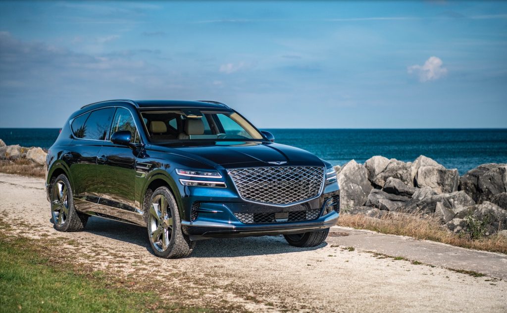 Promo shot of a Genesis GV80 crossover SUV parked by the water.