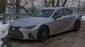 A silver 2021 Lexus IS 350 AWD F Sport with Dynamic Handling Package parked by a snowy forest