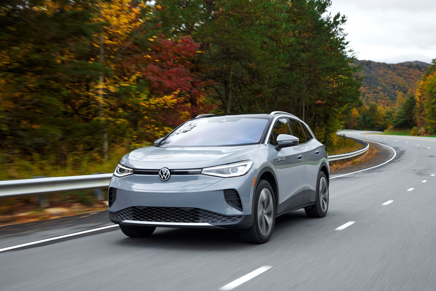 2021 Volkswagen ID.4 AWD all-electric compact SUV in gray driving on a forest highway