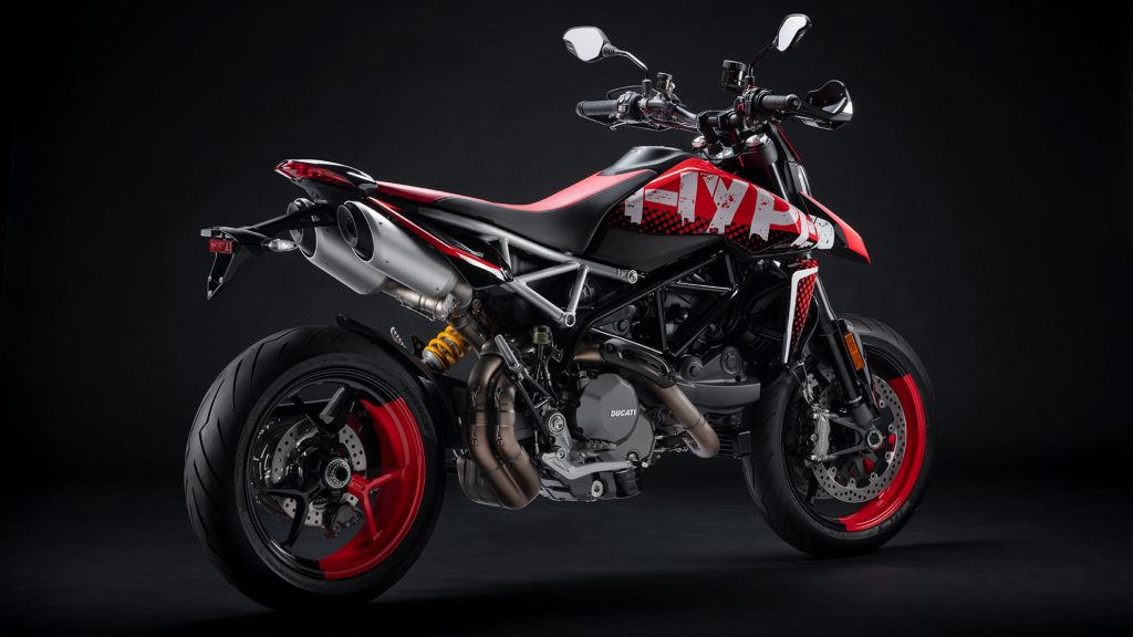 The rear 3/4 view of a red-black-and-white Graffiti-liveried 2022 Ducati Hypermotard 950 RVE in a black studio
