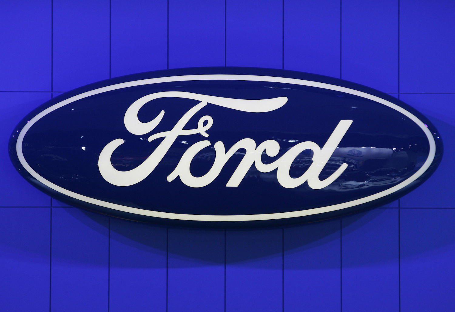 Blue Ford sign hanging on a bright blue wall.