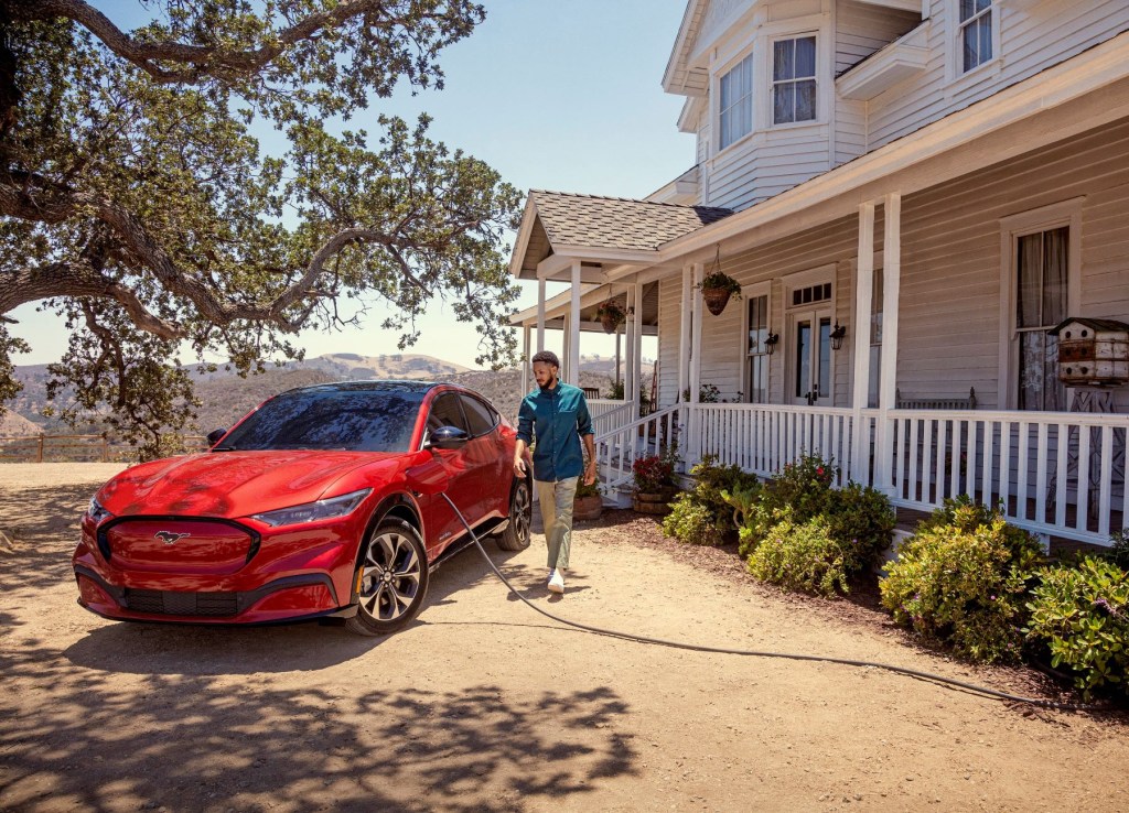 2022 Ford Mustang Mach-E all-electric compact SUV charging outside of a house