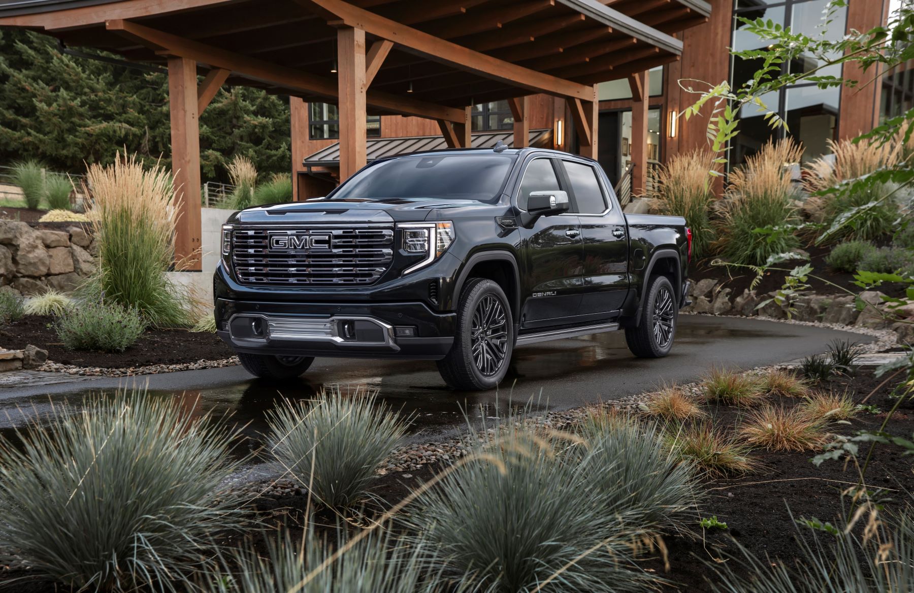 2022 GMC Sierra 1500 Denali Ultimate premium pickup in full size parked in the driveway of a luxury forest house