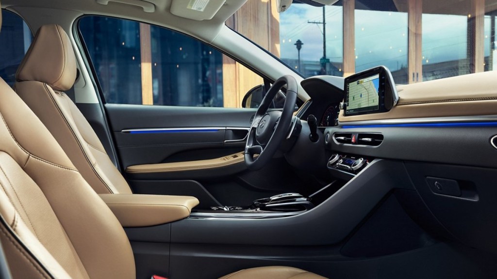 The inside of a 2022 Hyundai Sonata with tan seating and a tan dashboard, and blue ambient lighting