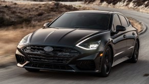 A Black 2022 Hyundai Sonata N-Line Night driving on a desert road with its LED headlights on