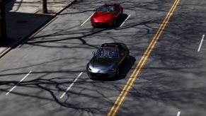 An overhead shot of 2022 Mazda MX-5 Miata sports car roadster convertible models in gray and red