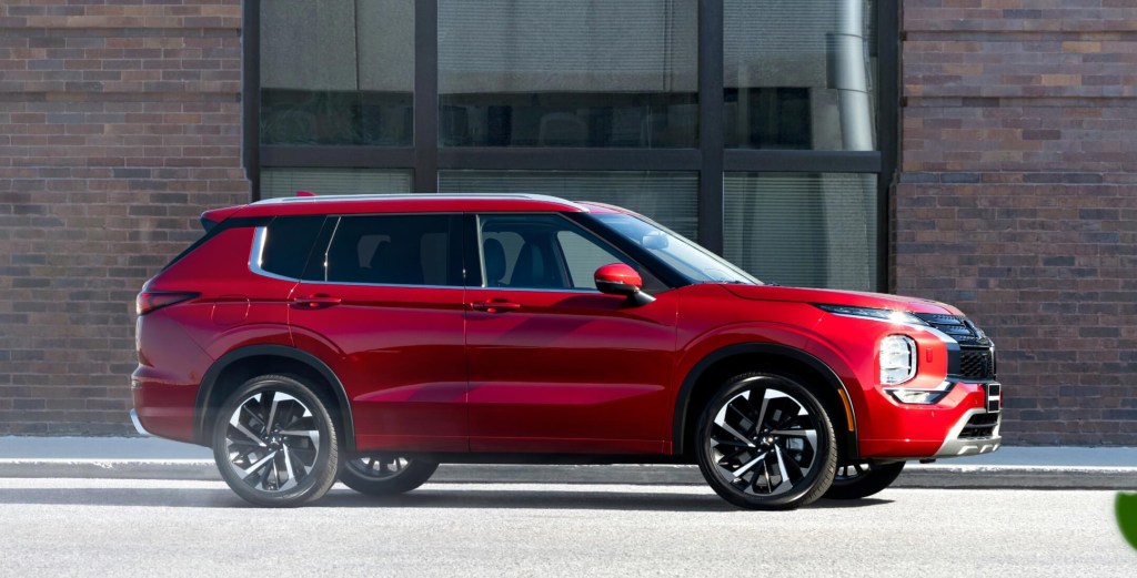 A red 2022 Mitsubishi Outlander parked in a city.