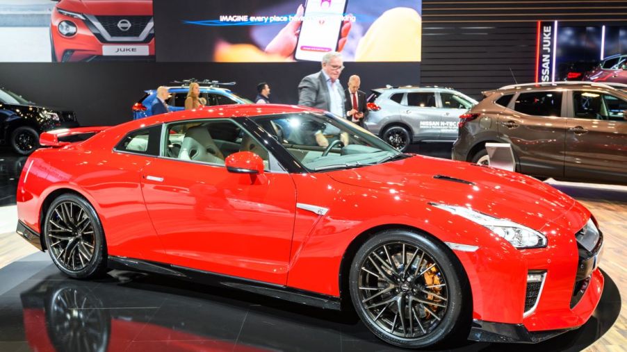 A 2022 Nissan GT-R available as a 2022 Nissan GT-R Nismo in orange at an expo indoors.