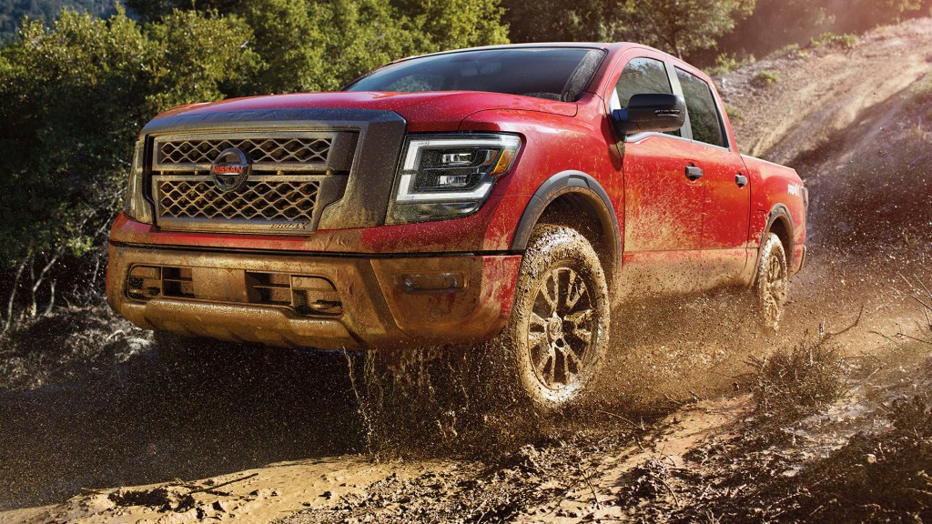 A red 2022 Nissan Titan Pro4X driving off-road. There are a few reasons not to buy the full-size pickup truck.