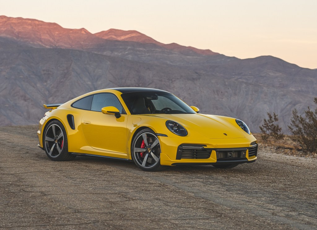 A yellow 2022 Porsche 911 Turbo on a desert mountain road