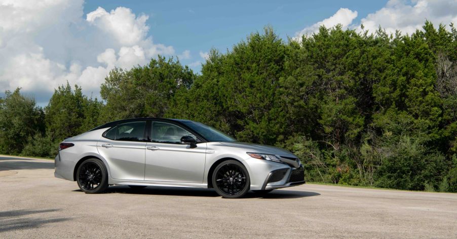 The 2022 Toyota Camry Hybrid XSE midsize sedan in silver with a black roof which gets excellent gas mileage