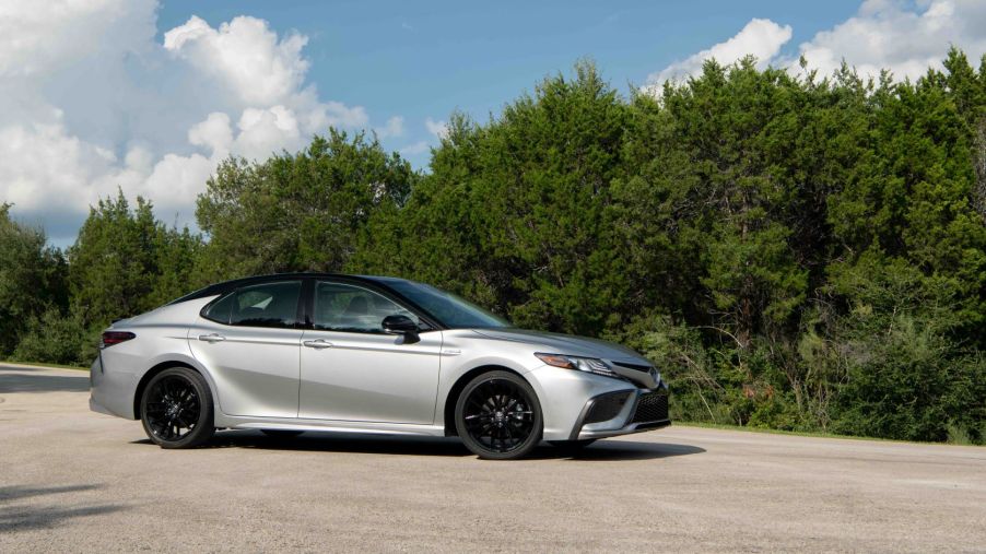 The 2022 Toyota Camry Hybrid XSE midsize sedan in silver with a black roof which gets excellent gas mileage