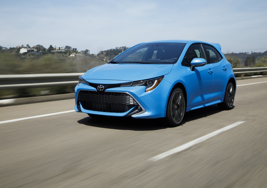 A blue 2022 Toyota Corolla XSE Hatchback driving down a road