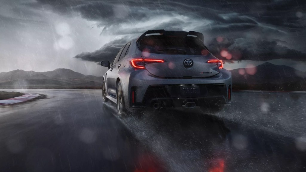 A hatchback sportscar driving through the rain.