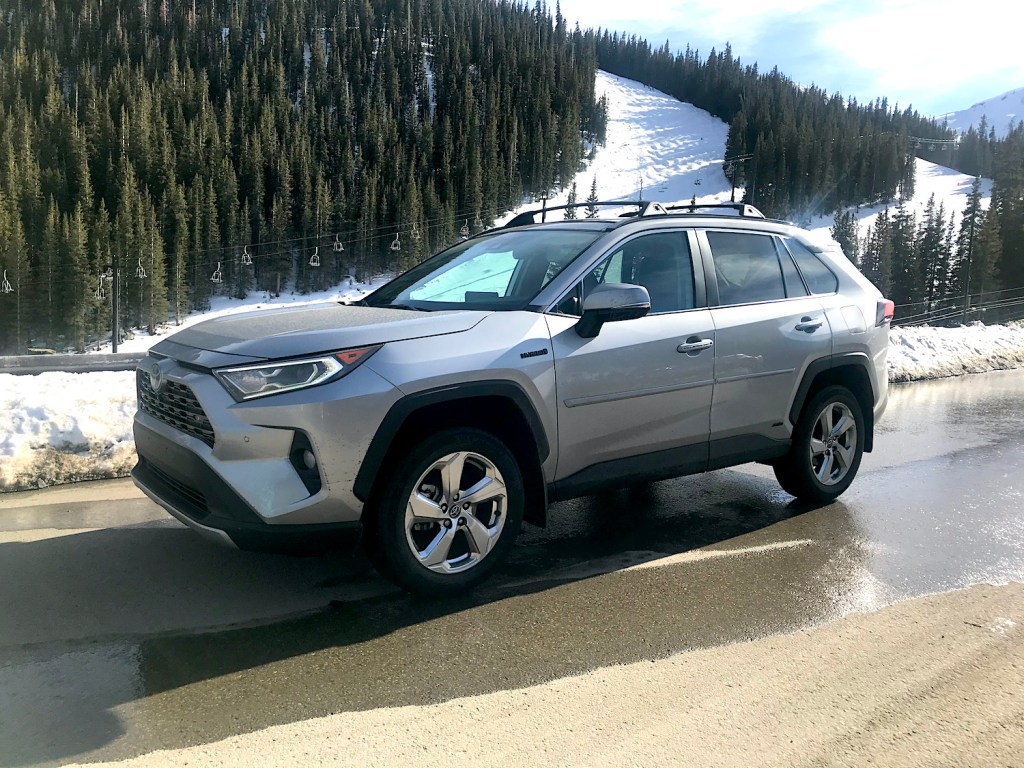 2022 Toyota RAV4 hybrid small SUV side view by a snow mountain