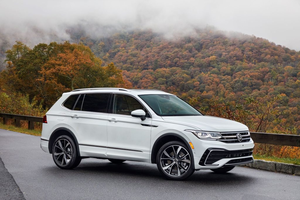 A white 2022 Volkswagen Tiguan parked on a road in a mountainous area. 