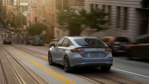 2022 Honda Civic Sport Touring hatchback model driving down a city street