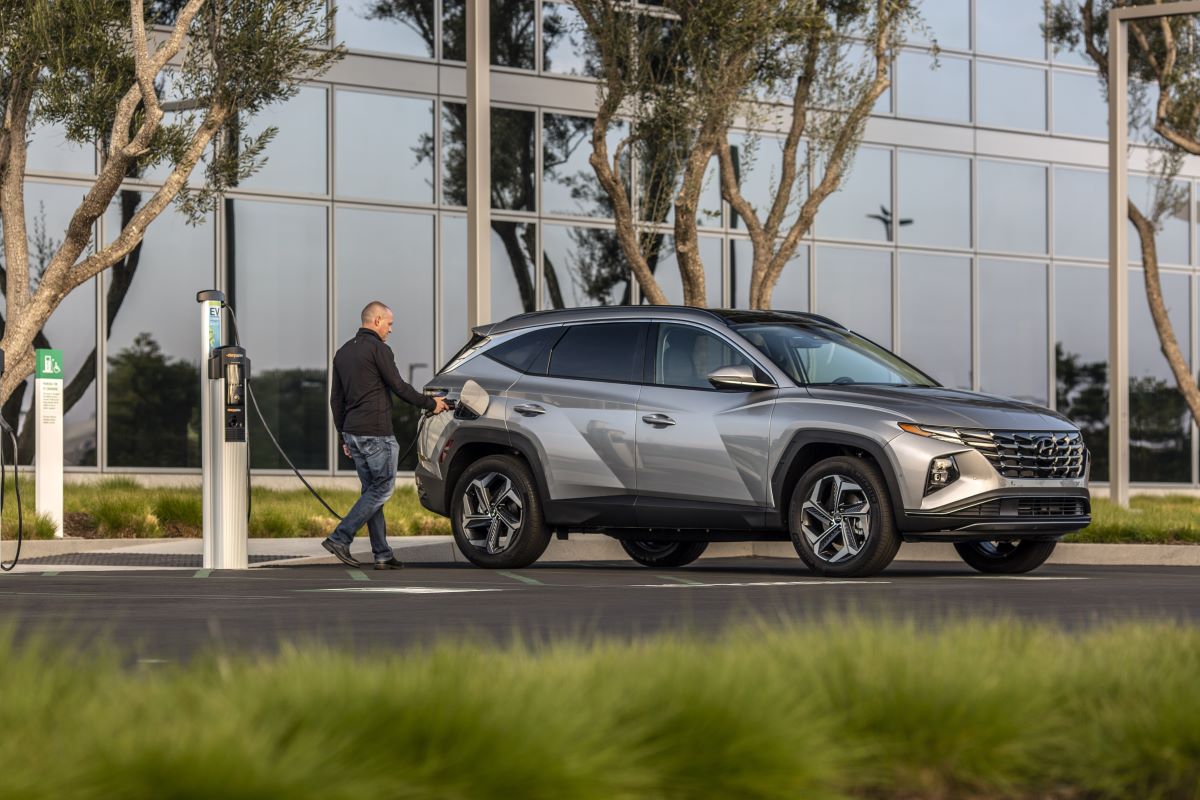 A man plugs in a 2022 Tucson PHEV, one of the best electric SUVs