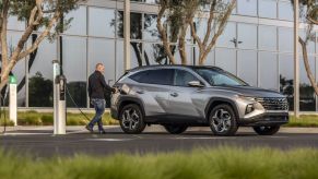 A man plugs in a 2022 Tucson PHEV, one of the best electric SUVs