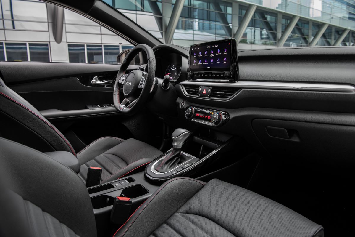 2022 Kia Forte GT-Line interior in black cloth and faux leather trim, with a 10-inch touchscreen infotainment system and automatic transmission