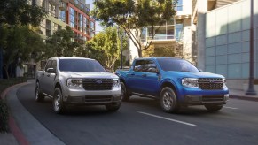 A pair of Ford Maverick compact trucks navigate an urban environment.