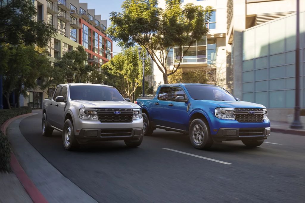 A pair of compact truck Ford Maverick models navigate an urban environment. 