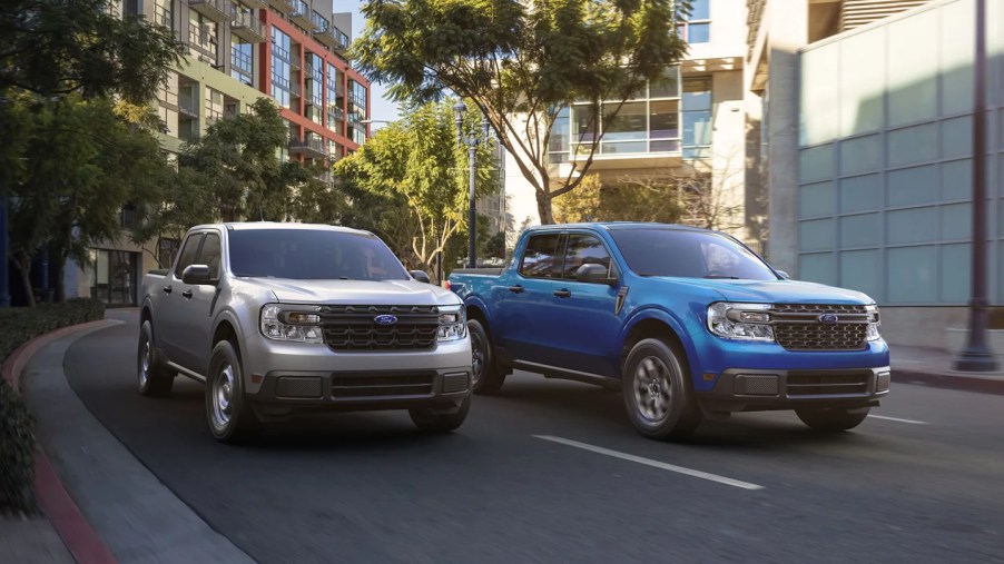 A pair of 2022 Ford Maverick small trucks navigate an urban environment.