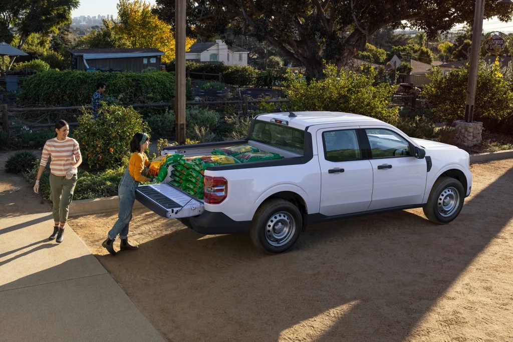 A white Ford Maverick has garden soil loaded into its bed. Showing off its capability as a compact pickup truck.