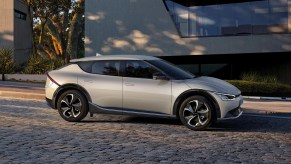 A silver 2022 Kia EV6 model sits outside of a buidling.