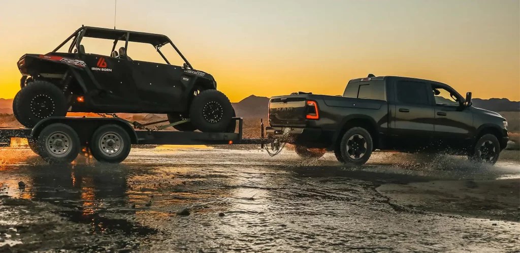 A 2022 Ram 1500 shows off its towing capability as a full-size truck in a watery terrain.
