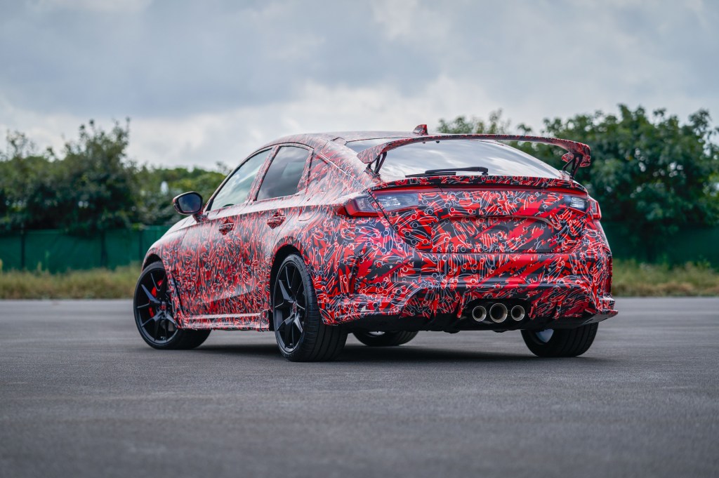 The rear 3/4 view of the red-black-and-white-camouflaged 2023 Honda Civic Type R prototype at the Nurburgring