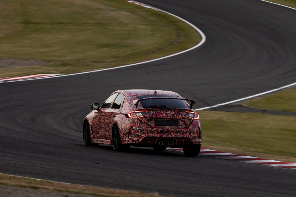 The rear 3/4 view of a red-camouflaged 2023 Honda Civic Type R prototype setting a Suzuka Circuit lap record
