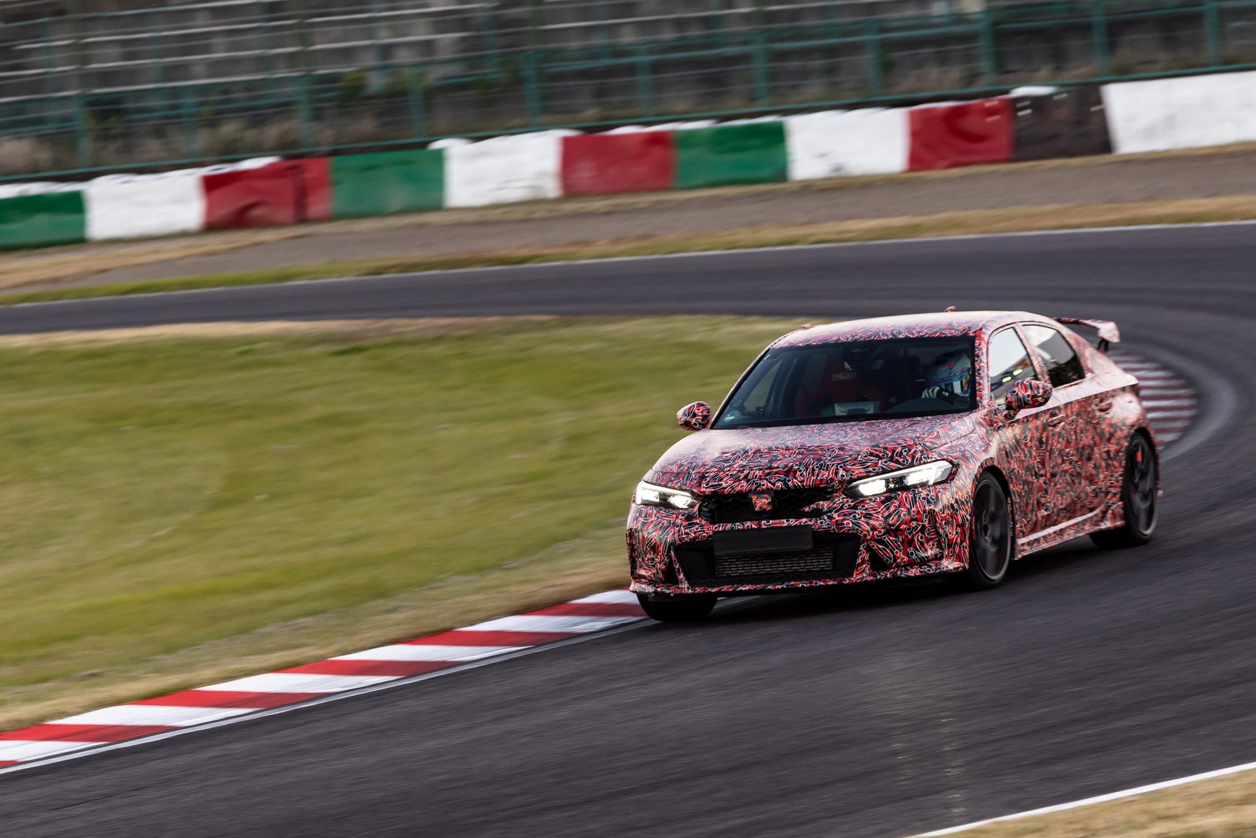 A red-camouflaged 2023 Honda Civic Type R prototype setting a Suzuka Circuit lap record
