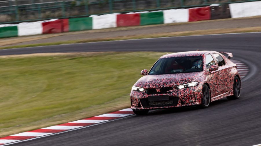 A red-camouflaged 2023 Honda Civic Type R prototype setting a Suzuka Circuit lap record