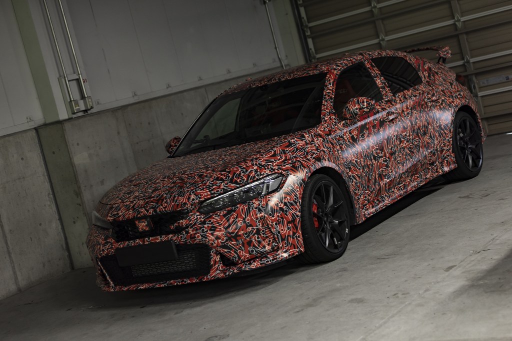 The red-and-white-camouflaged 2023 Honda Civic Type R prototype in a garage