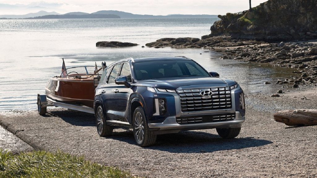 A dark blue 2023 Hyundai Palisade towing a boat out of the water. 