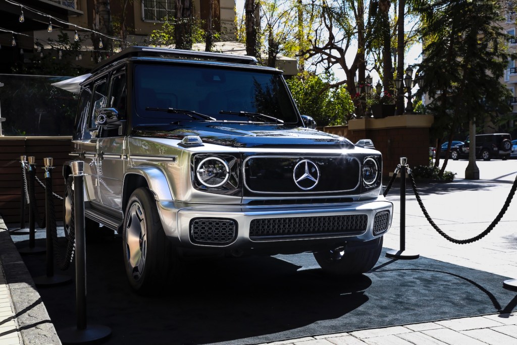 Mercedes' all-electric G-Class SUV concept vehicle parked in front of a hotel.