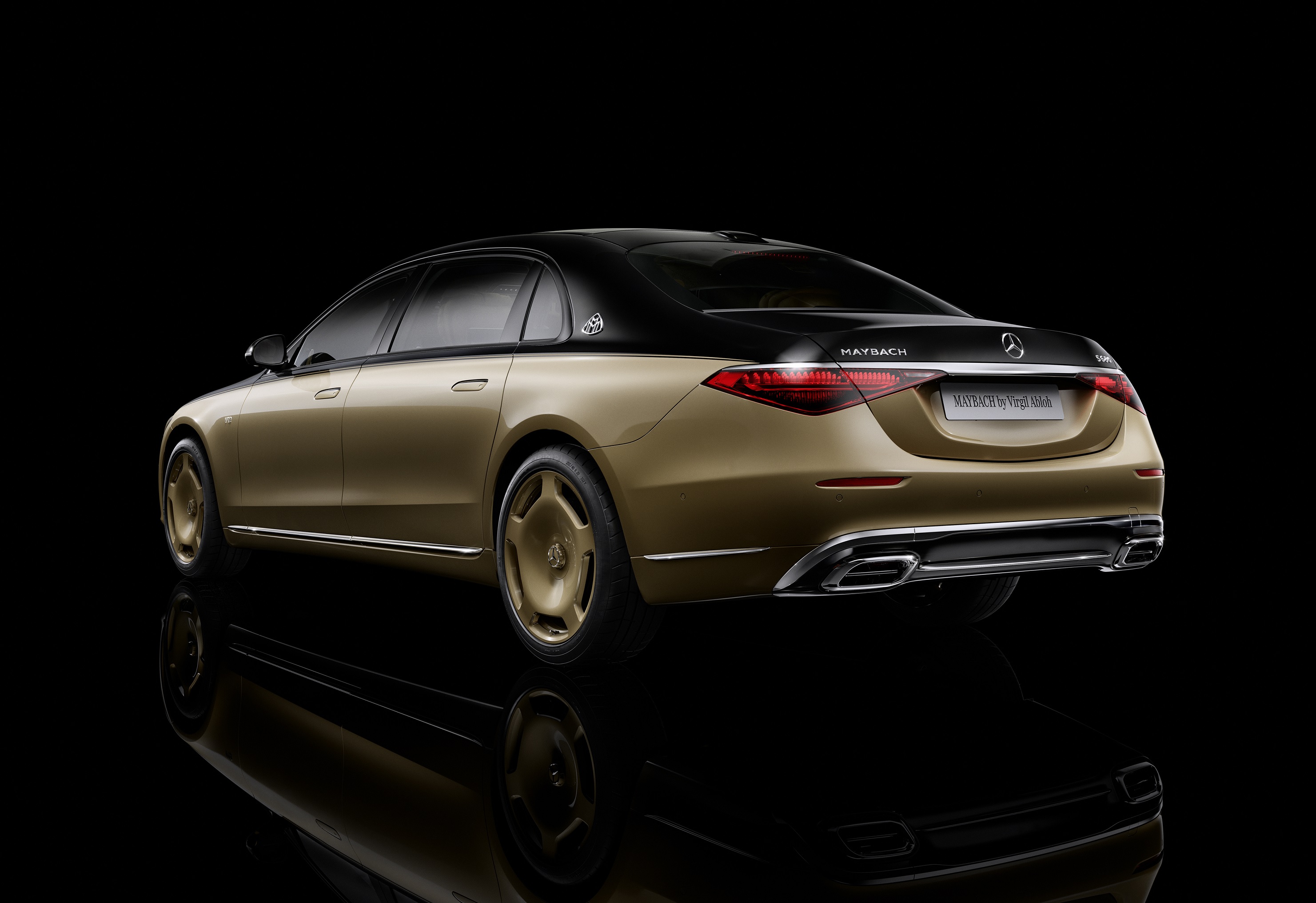 The rear 3/4 view of the black-and-gold 2023 Mercedes-Maybach S 680 by Virgil Abloh against a black background