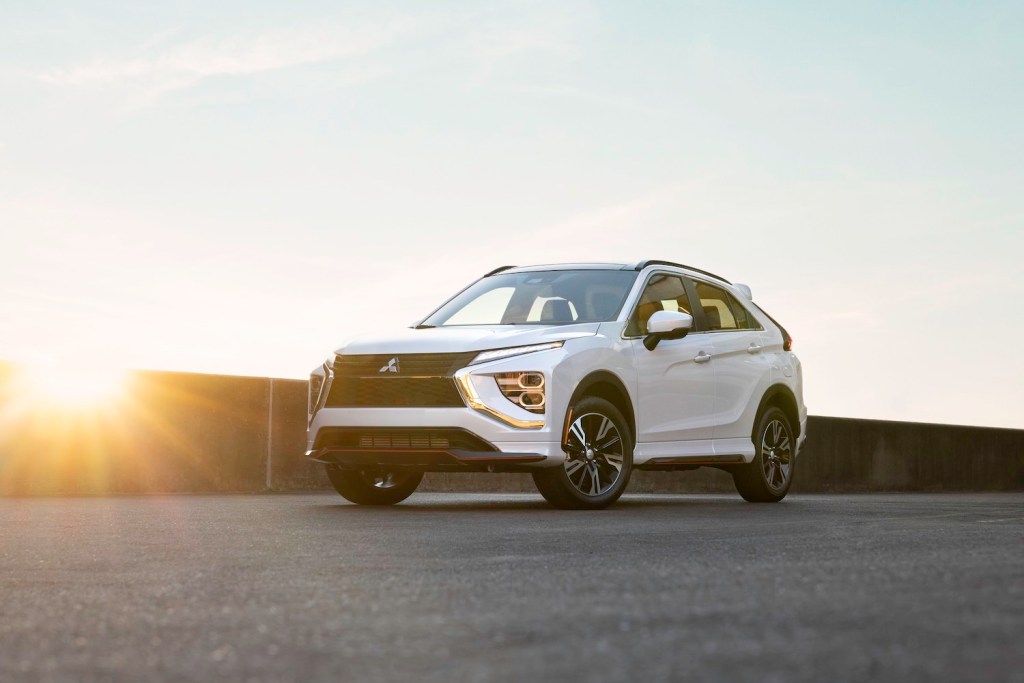 Promo photo of the new 2023 Mitsubishi Eclipse Cross compact SUV parked on concrete in front of a setting sun.