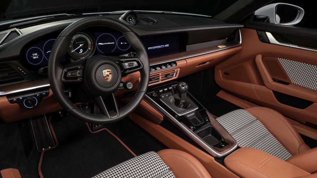 A 2023 Porsche 911 Sport Classics nougat leather seats with black-and-white checkered inserts and black-and-nougat dashboard
