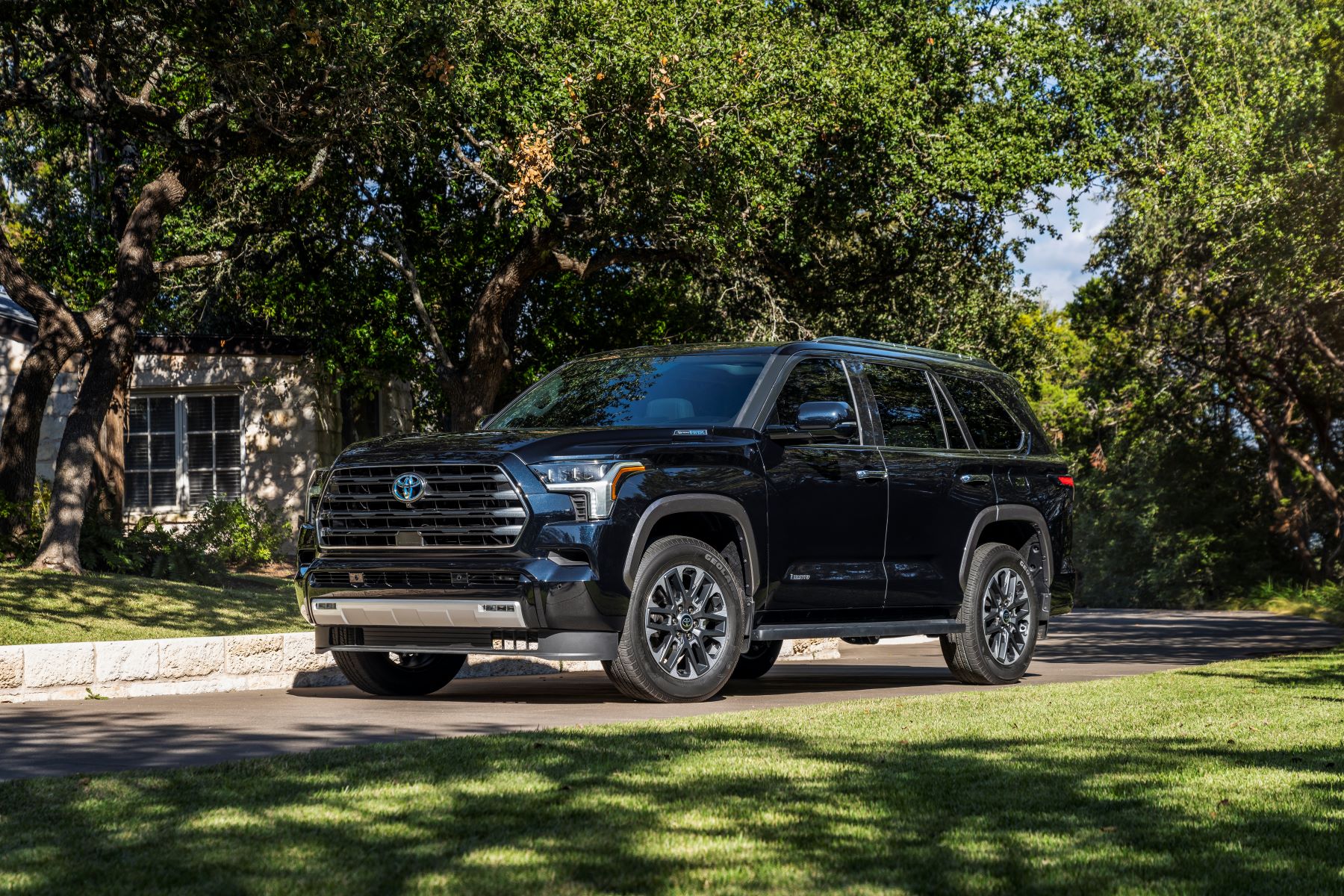 The 2023 Toyota Sequoia Limited full-size SUV parked on a driveway near a shaded lawn
