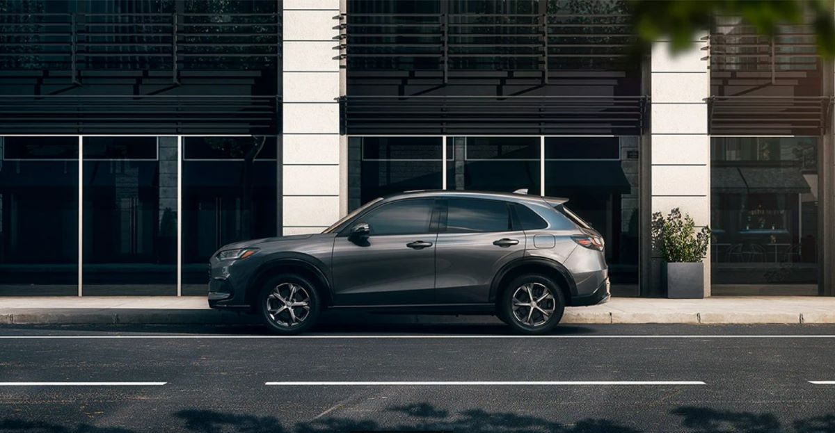 Side profile of a 2023 Honda HR-V subcompact SUV in Urban Gray Pearl on an empty city street
