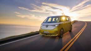 2024 Volkswagen ID. Buzz all-electric van with a yellow and white color option driving down a highway with a sunset