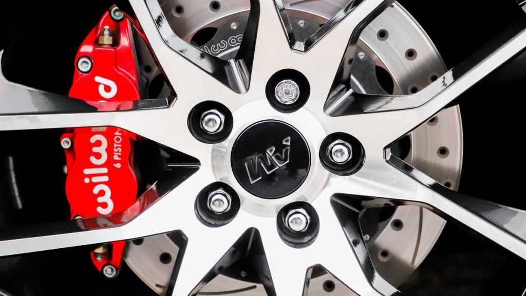 a wheel with red wilwood brakes with 5 lug nuts