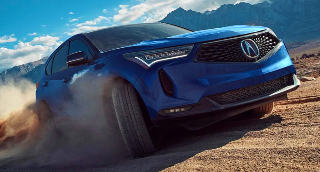 A blue 2022 Acura RDX small SUV is driving off-road. 