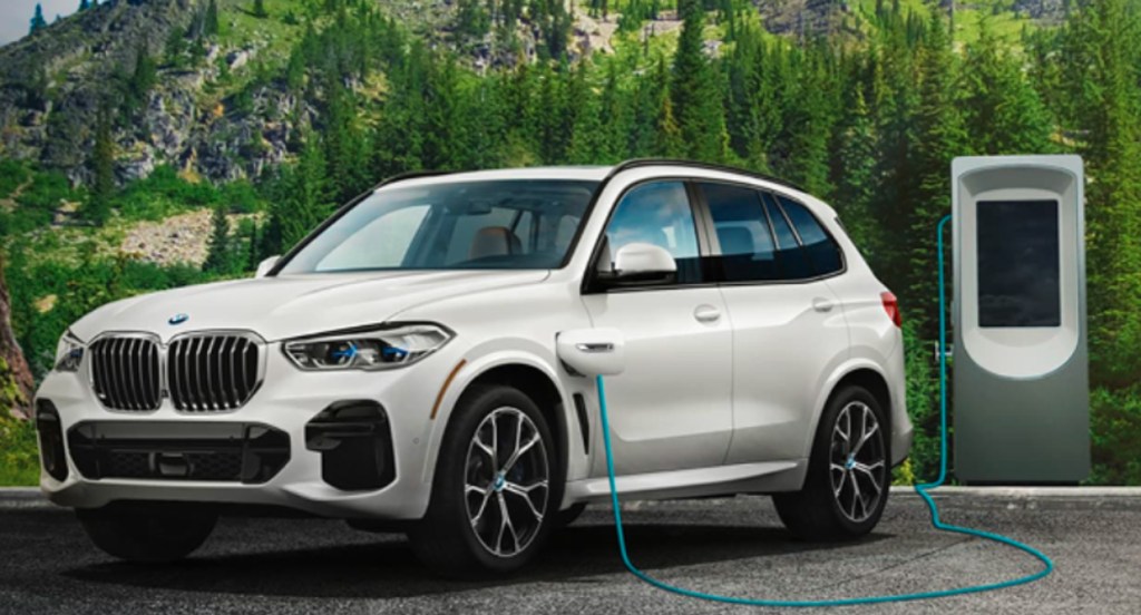 A white BMW xDrive45e luxury hybrid SUV is charging.