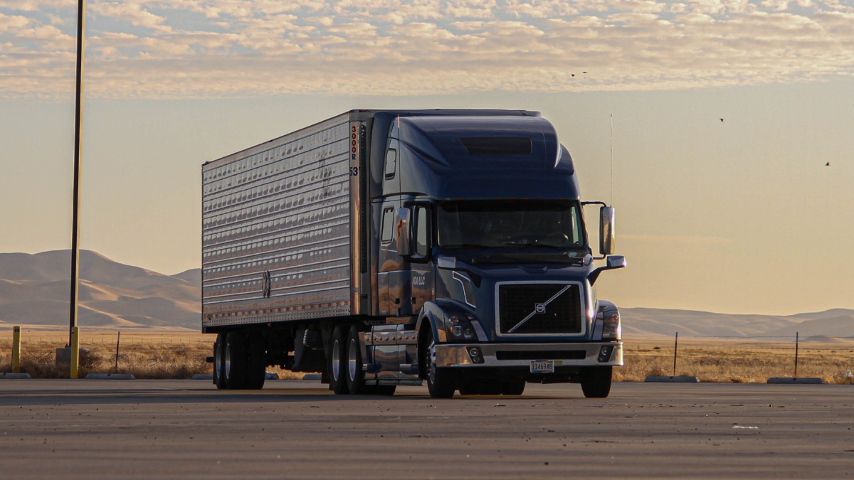 Blue semi-truck with mountains in the background, highlighting how California could ban 76,000 trucks by the end of 2022