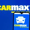 The CarMax logo on a smartphone and in the background